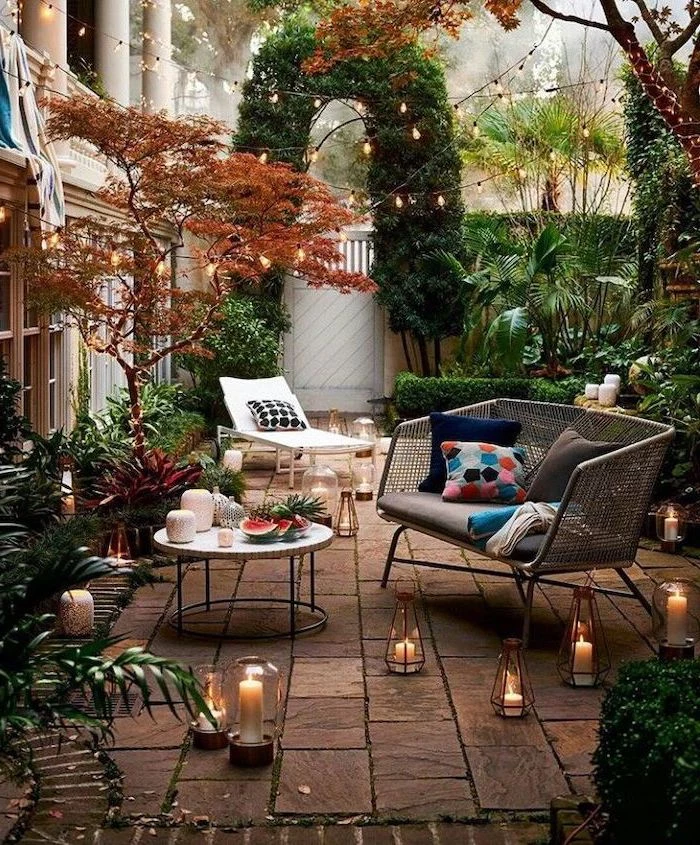 strings of lights, over the garden furniture, with colourful throw pillows, small backyard landscaping ideas