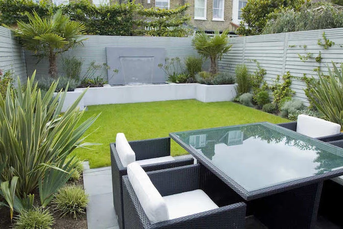 patch of grass, planted palm trees and bushes, garden design ideas, garden furniture, small fountain