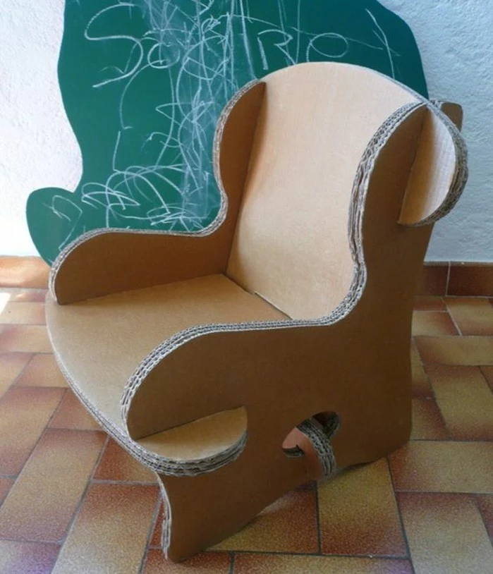 tiled floor, green chalkboard in the background, cardboard chair design, cardboard armchair