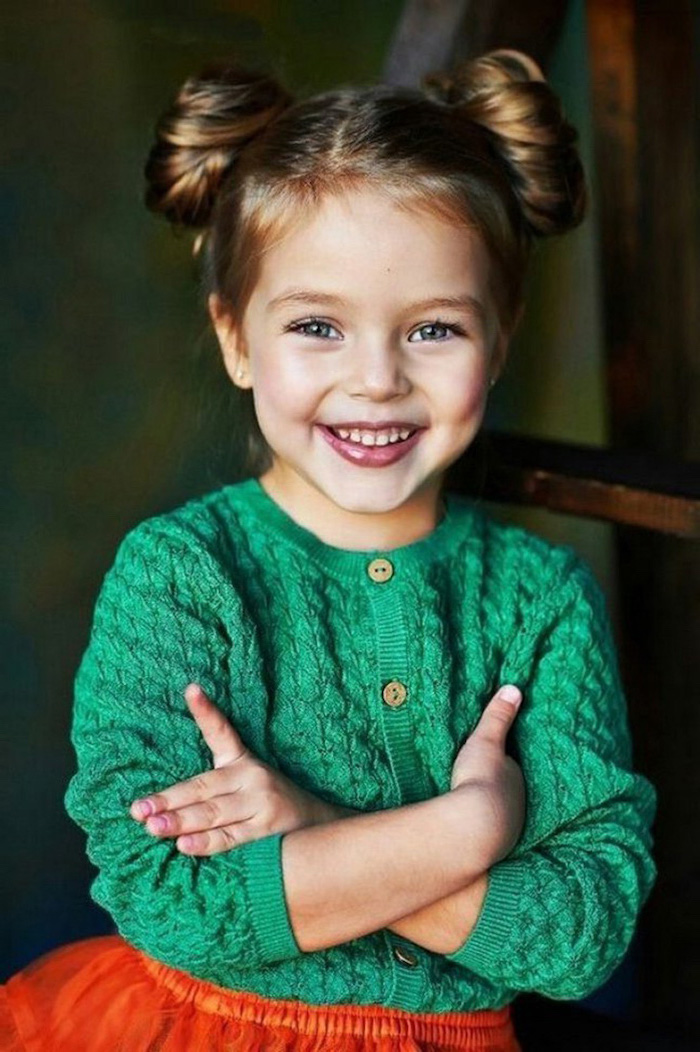 green cardigan, orange skirt, brown hair in two buns, cute hairstyles for little girls, princess leia inspired