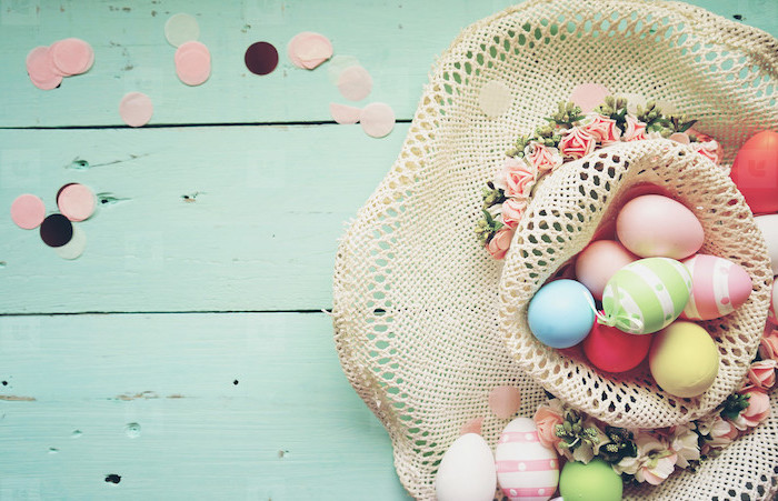 colourful dyed eggs, inside a hat, with flowers on the side, dying easter eggs with food coloring, turquoise backgorund