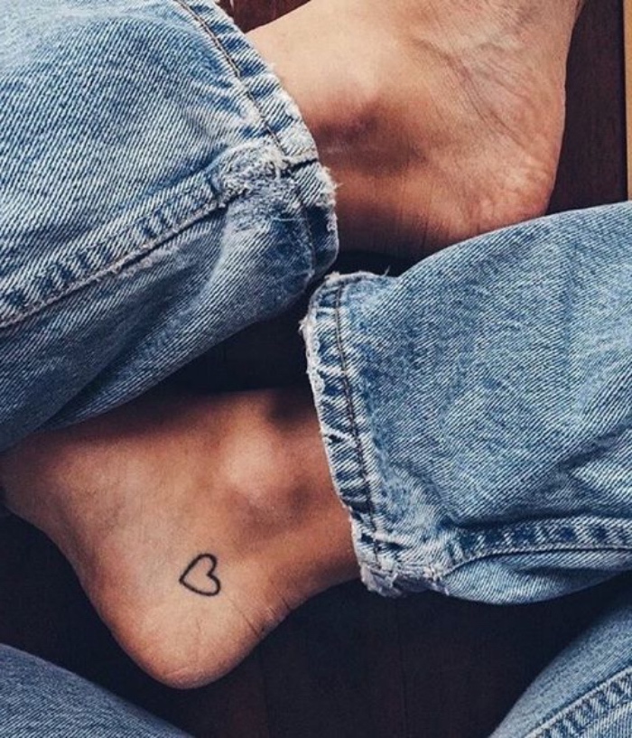 small heart ankle tattoo, person wearing washed jeans, small bestfriend tattoos, crossed legs