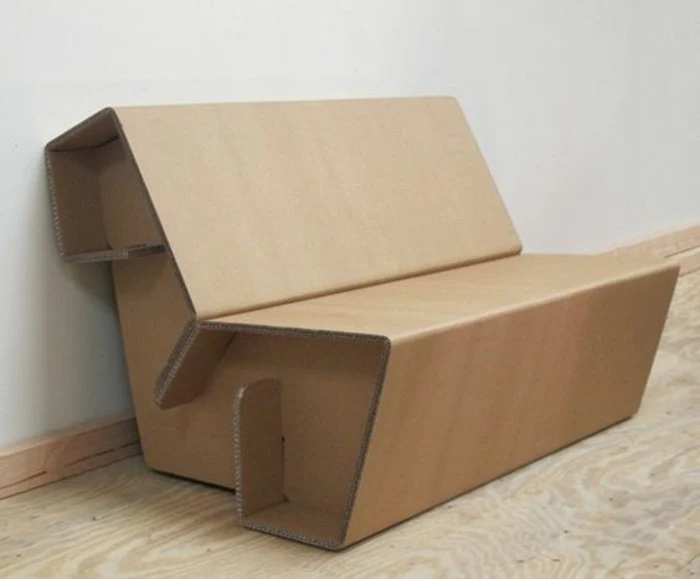 cardboard sofa, on a wooden floor, cardboard chair, in front of a white wall