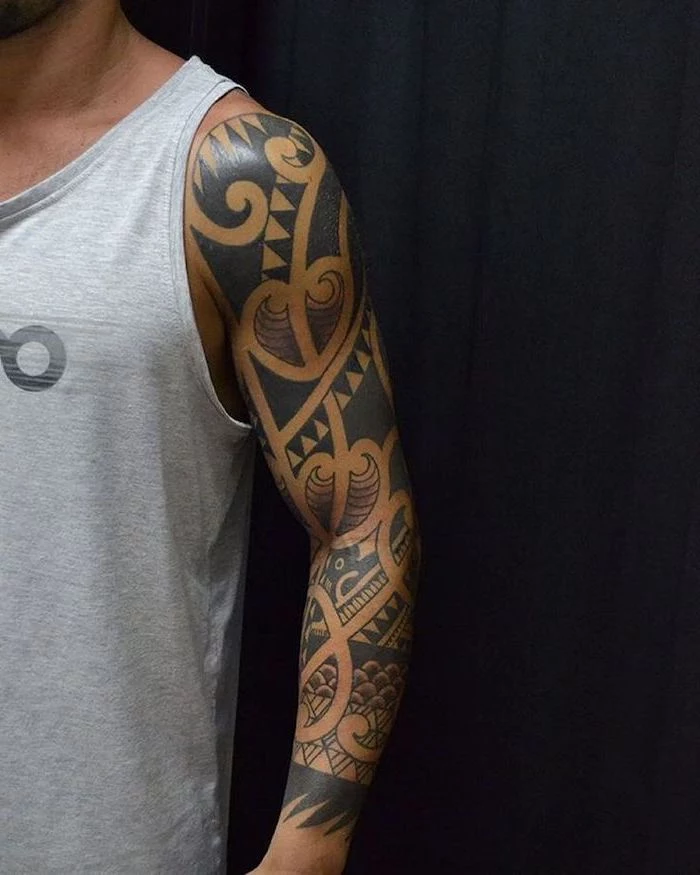 black and white, arm sleeve tattoo, man wearing a grey top, in front of a black background, tattoo designs for men