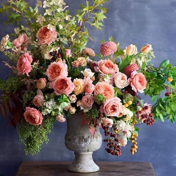 orange and yellow flowers, large flower bouquet, in a vintage vase, silk floral arrangements, on a wooden table