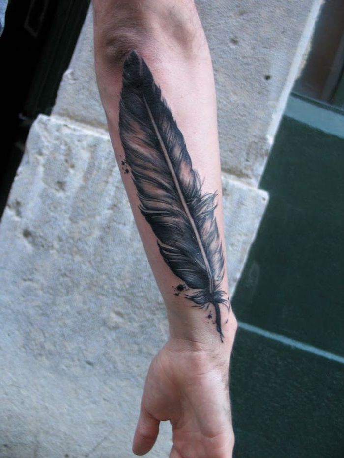 black and white feather, forearm tattoo, arm tattoos for men, cement blocks in the background