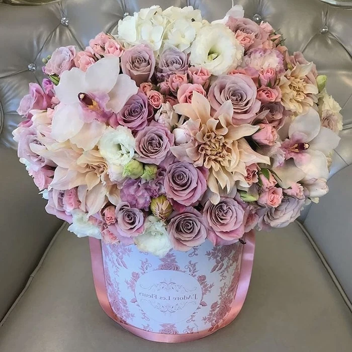 pink purple and white flowers, large flower bouquet, in a carton box, silk floral arrangements, on a grey leather sofa