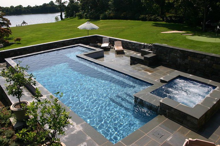 large pool, with a small hot tub, surrounded by black tiles, garden patio ideas, garden furniture
