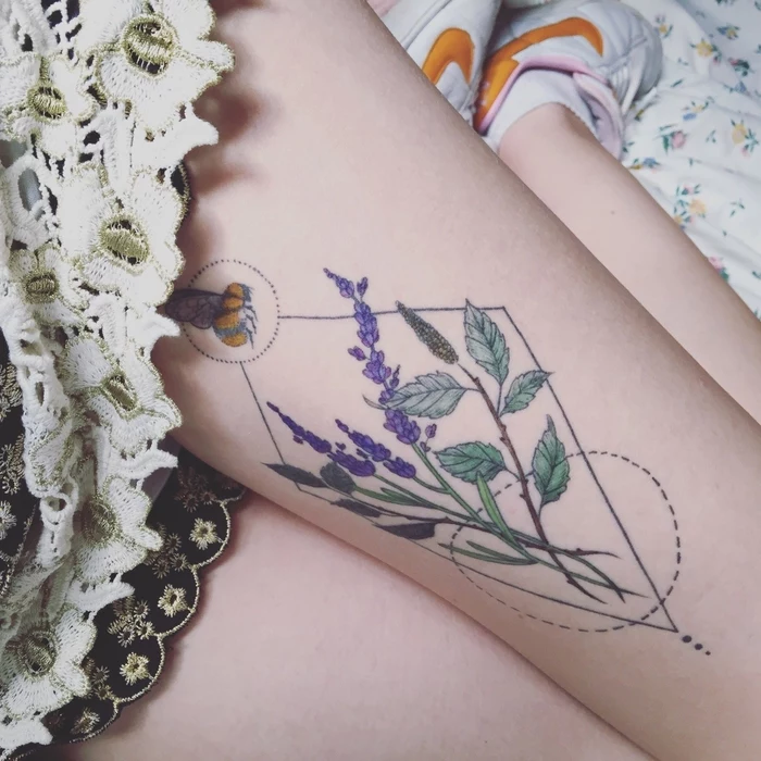 bee landing on lavender, circles and triangles around, tattoo on a woman's thigh, geometric flower tattoo