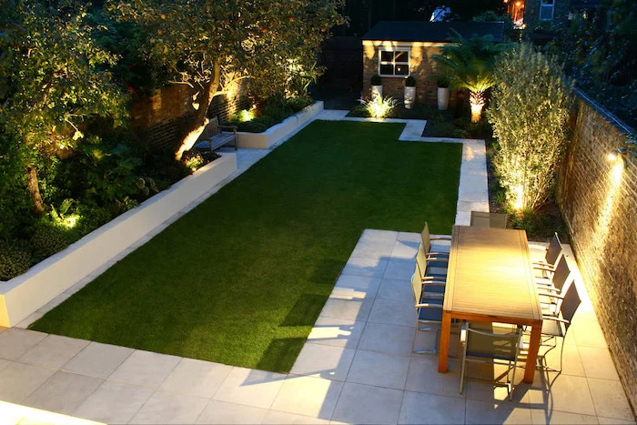 lots of lights, patch of grass, garden furniture, on a tiled floor, small backyard designs, planted trees and bushes