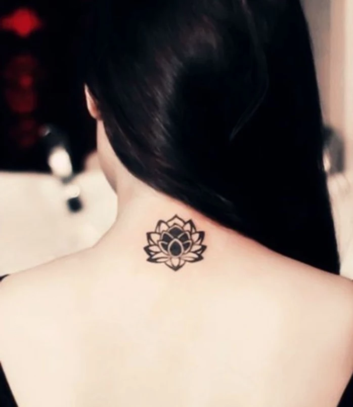 small lotus flower back tattoo, small tattoos for guys, woman with a long black hair, blurred background