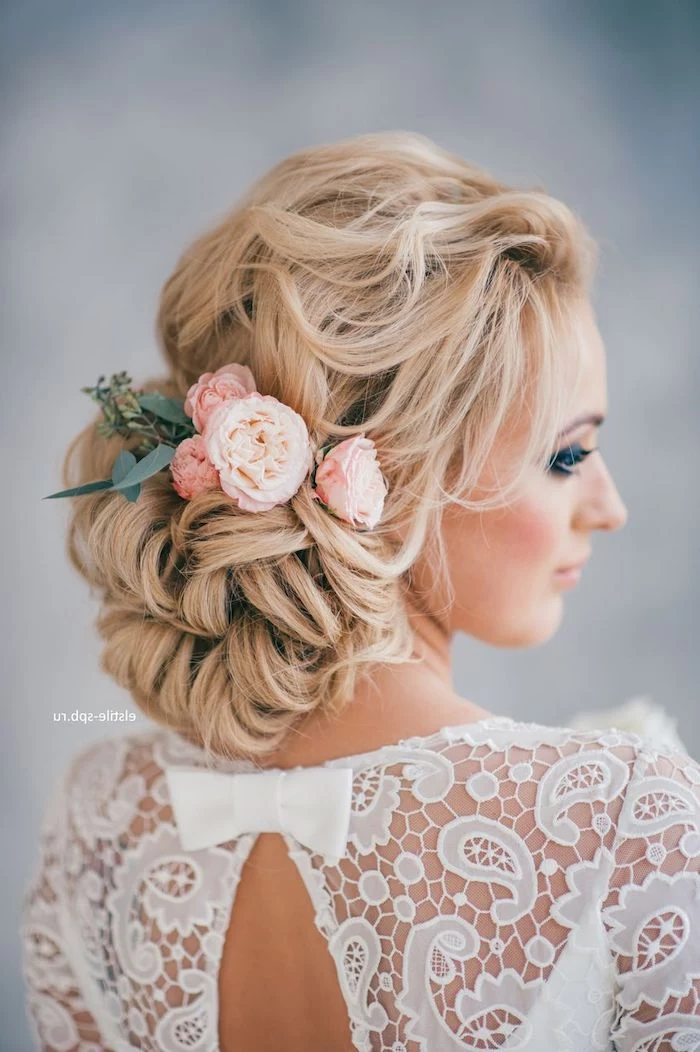 white dress with a bow, long blonde hair in a low updo, roses hair accessory, wedding hairdos