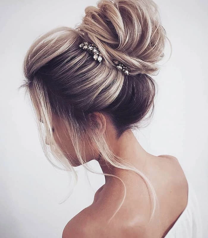 white top, wedding hairstyle, messy bun, small hair accessories, loose strands of hair
