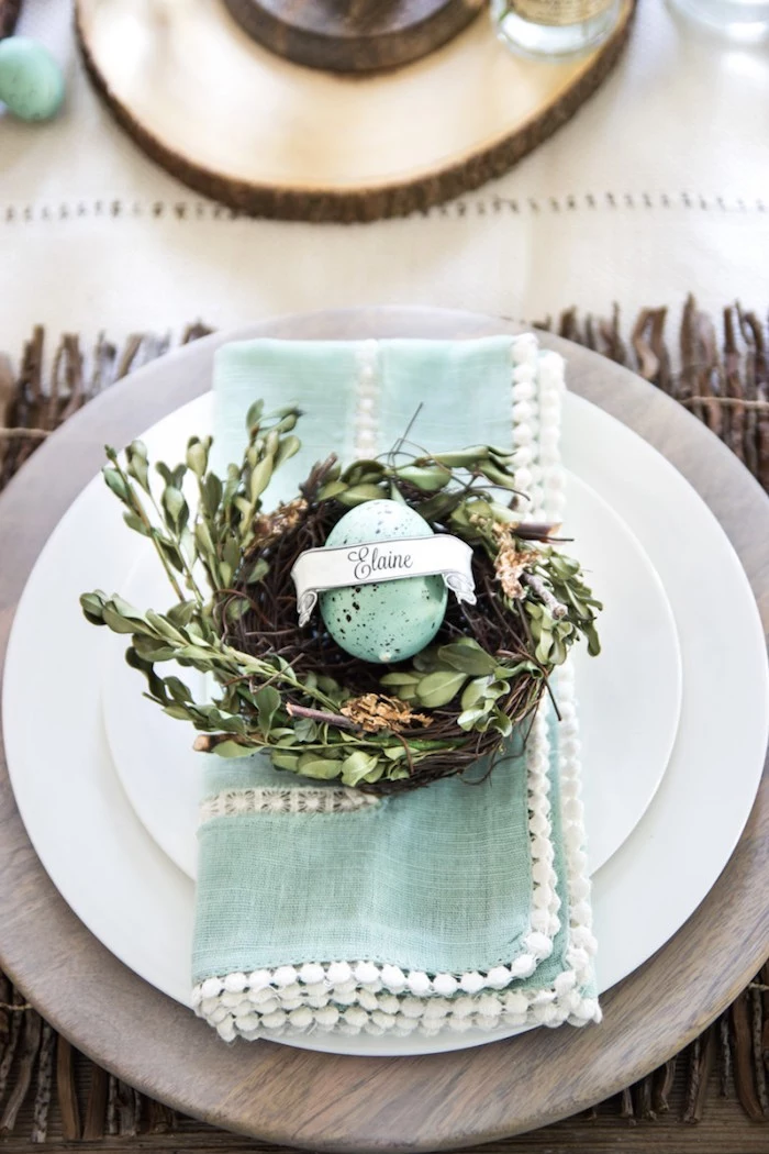 blue napkin, on a white plate, easter table decorations ideas, blue dyed egg on a tree branch