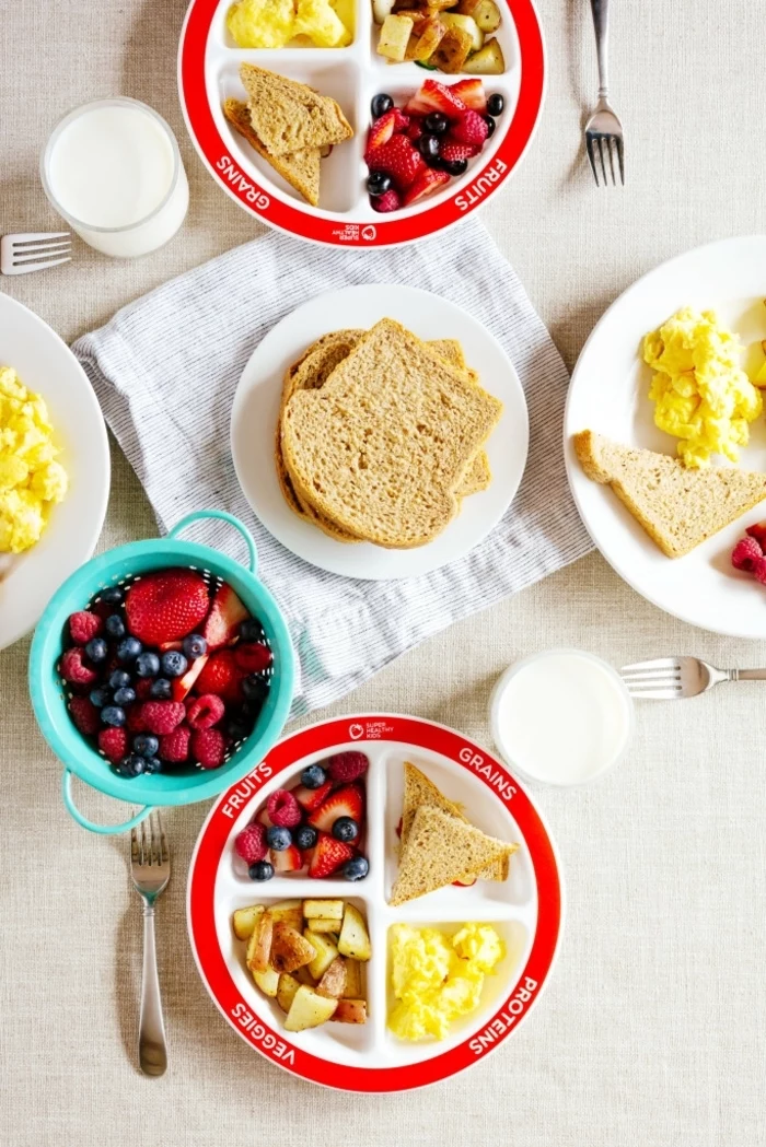 scrambled eggs, bread slices, nutrition plan, blue bowl, full of blackberries and strawberries, glasses of milk