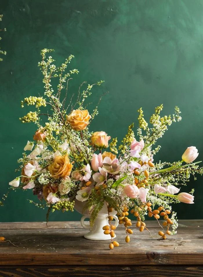 large orange and pink flower bouquet, in a small white vase, on a wooden table, flower arrangement ideas