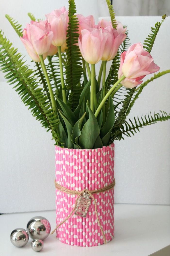 pink tulips, fern leaves, how to arrange flowers, vase made out of pink paper straws, on a white countertop