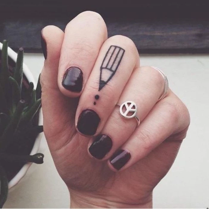 pencil finger tattoo, woman wearing burgundy nail polish, small butterfly tattoos, silver rings