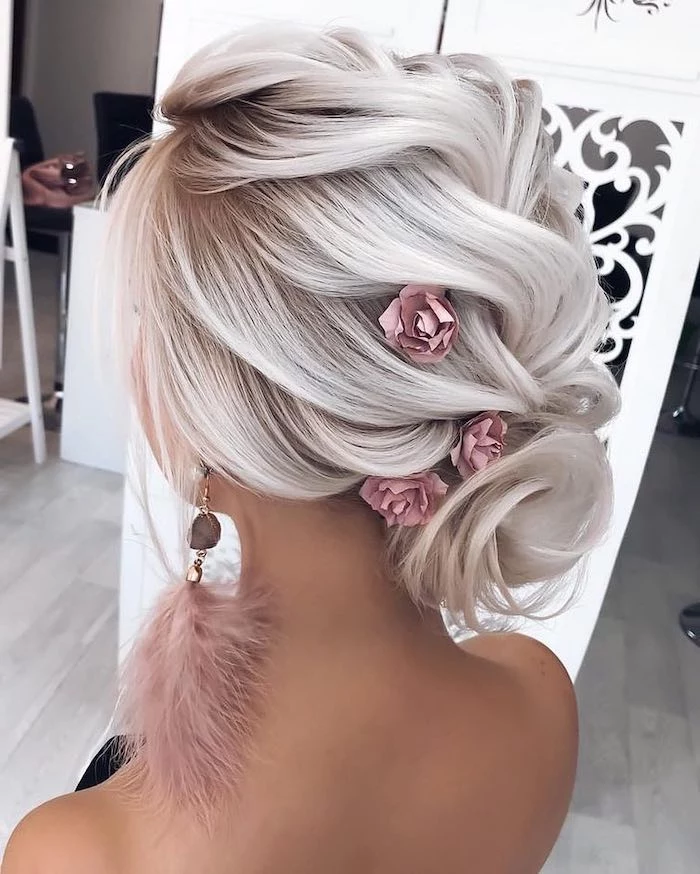 platinum blonde hair, pink feather earrings, wedding hairstyles, hair in a low updo, pink flowers in hair