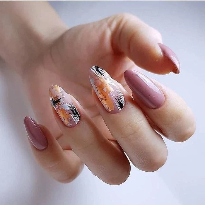 pink nail polish, nude matte nails, almond shaped nails, gold white and black abstract drawing on two nails