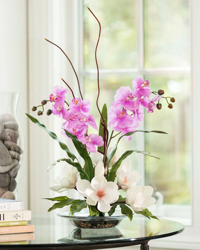 purple orchids and white magnolias, in a small glass plate, floral arrangements, on a glass coffee table