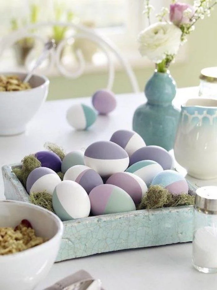 natural easter egg dye, purple and blue, pink and green, geometrical design eggs, in a ceramic bowl, full of moss