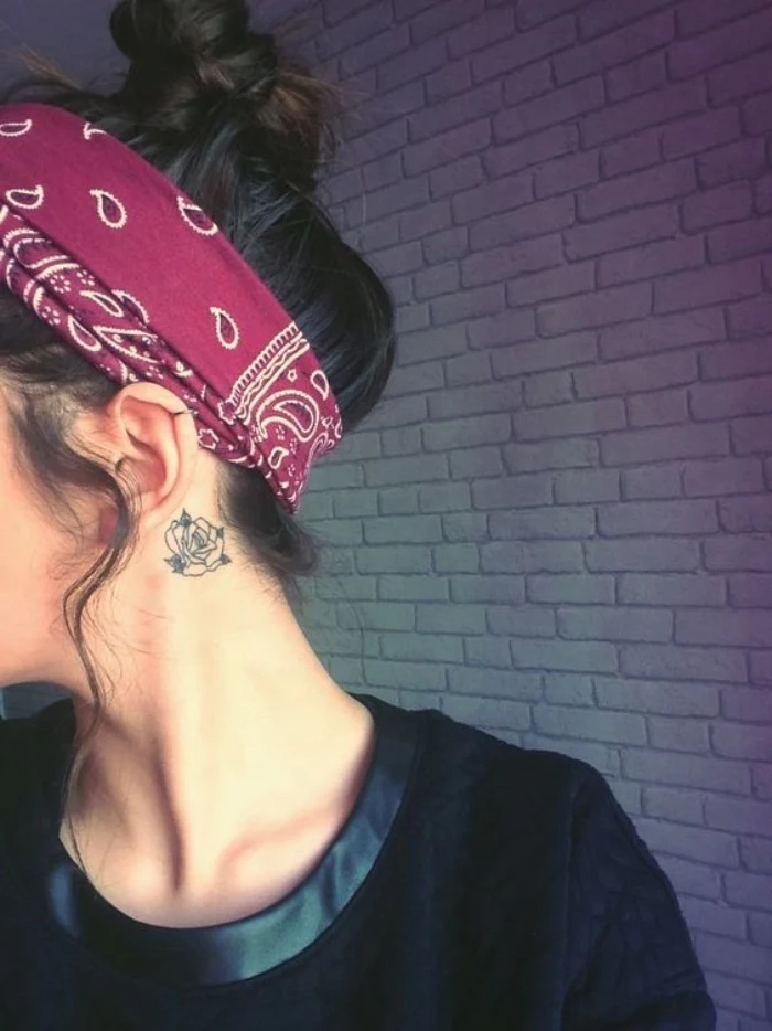 rose behind the ear tattoo, red bandana on the brown hair, in a messy bun, small sunflower tattoo