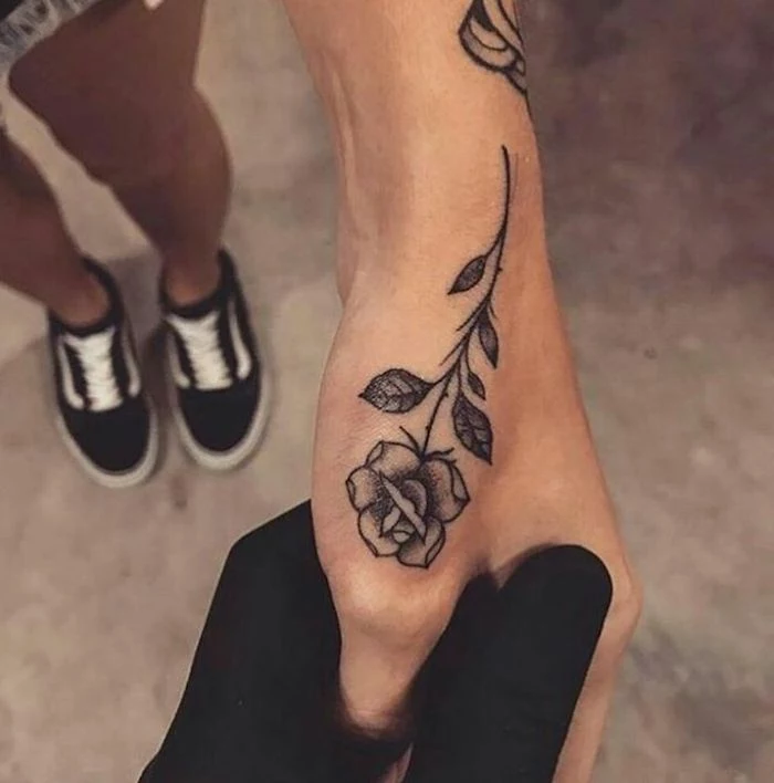 lion finger tattoo, black vans sneakers, large rose tattoo, hand with black gloves