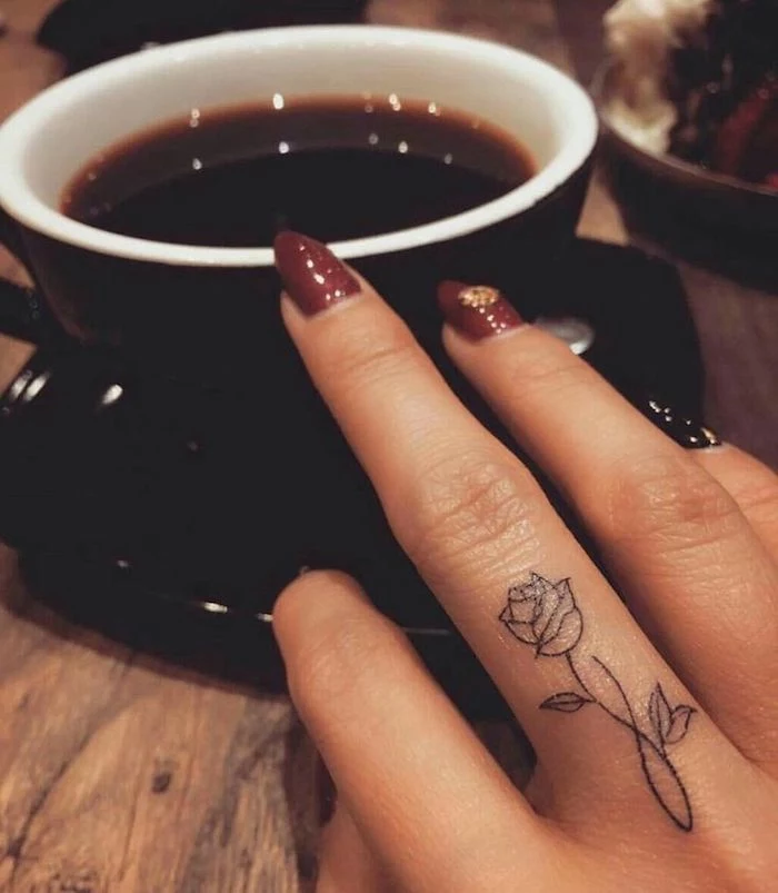 rose and infinity symbol, middle finger tattoo, rose finger tattoo, black cup of coffee