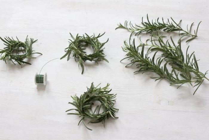 diy easter decorations, rosemary branches, with a green string, on a wooden countertop