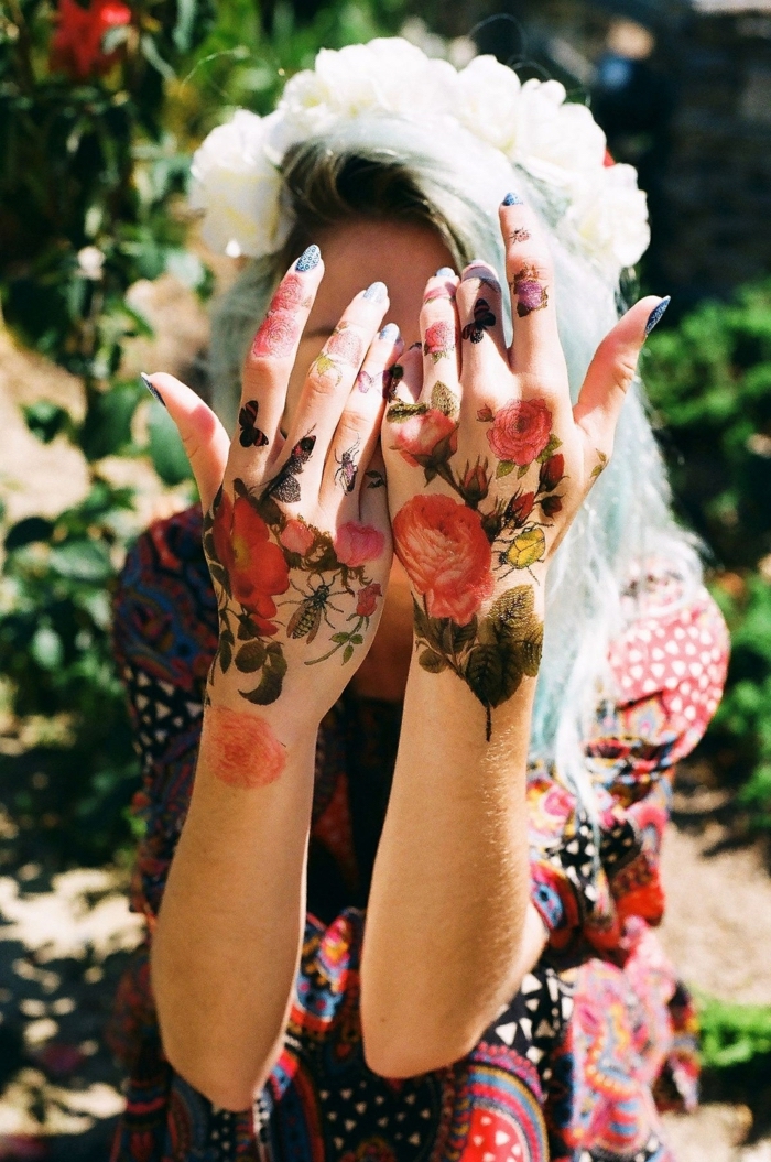 girl wearing a floral dress, rose finger tattoo, roses butterflies and bees, large tattoos on both hands