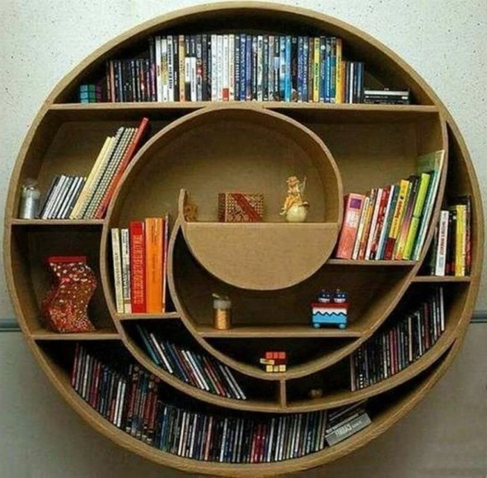 round cardboard bookshelf, lots of books, diy cardboard shelves, mounted on a white wall, diy bookshelf from cardboard
