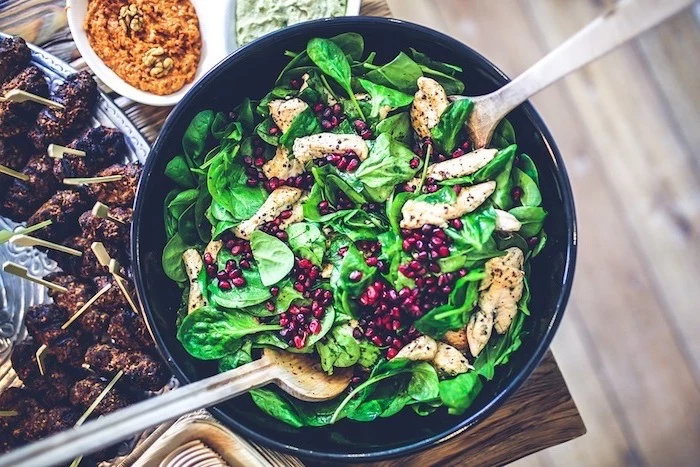 pomegranate seeds, basil salad, with meat, in a large black bowl, healthy eating meal plan