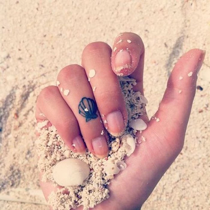 small seashell, ring finger tattoo, rose finger tattoo, hand holding beach sand, small seashells