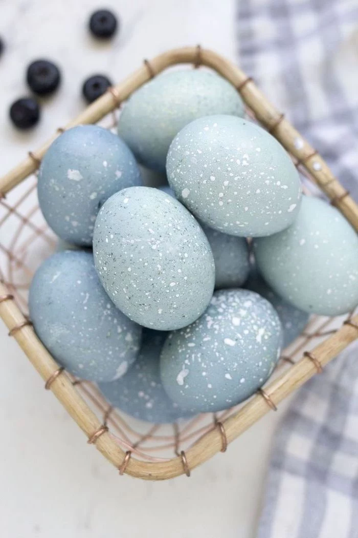 shades of blue, robin eggs, in a wooden basket, tie dye easter eggs, blueberries in the background