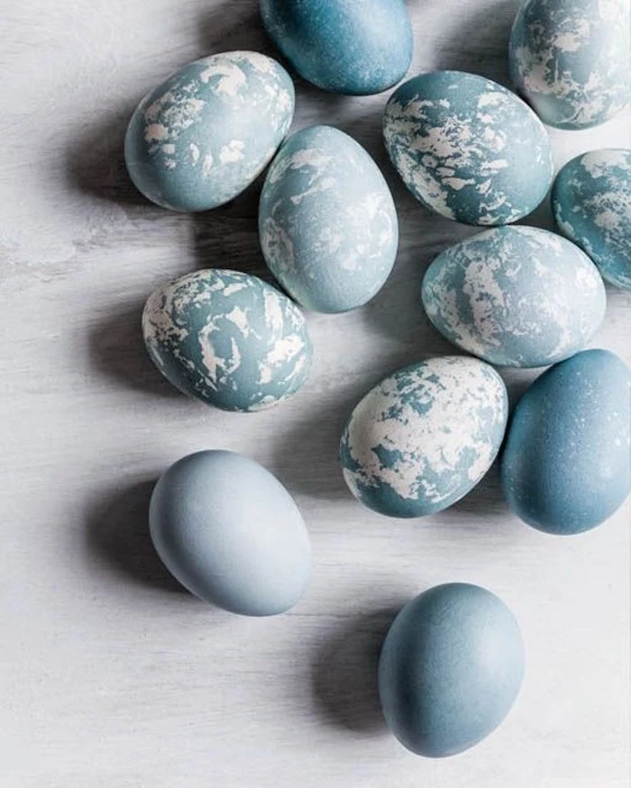 shades of blue, blue marble eggs, scattered on a wooden countertop, tie dye easter eggs