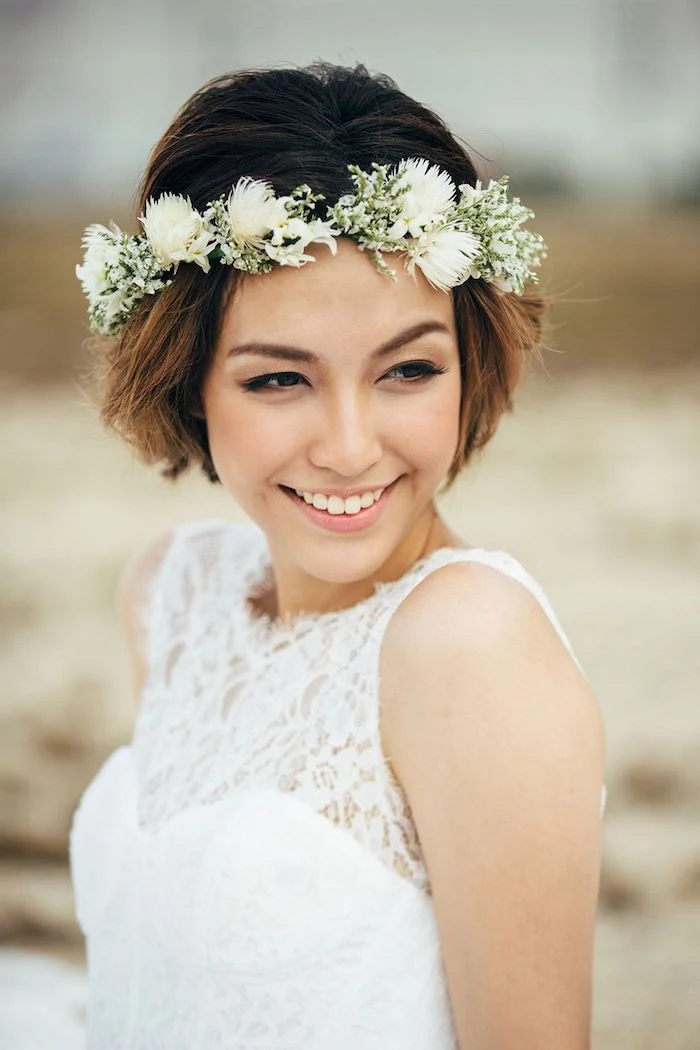 wedding updos for long hair, short brown hair, floral headband, white lace dress, blurred background