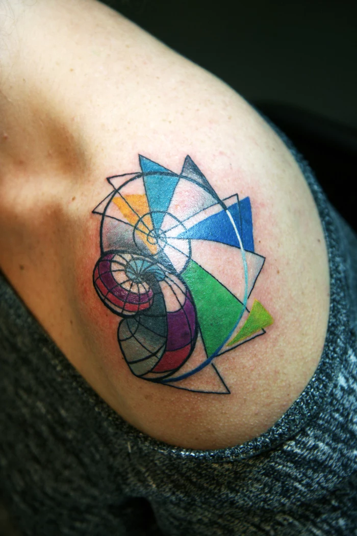 colourful shell shaped tattoo, on the shoulder, geometric tattoo meaning, grey blouse