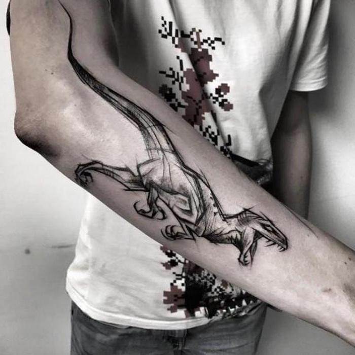 tribal tattoos for men, sketch of a raptor, jurassic park inspired, forearm tattoo, man wearing white shirt and jeans