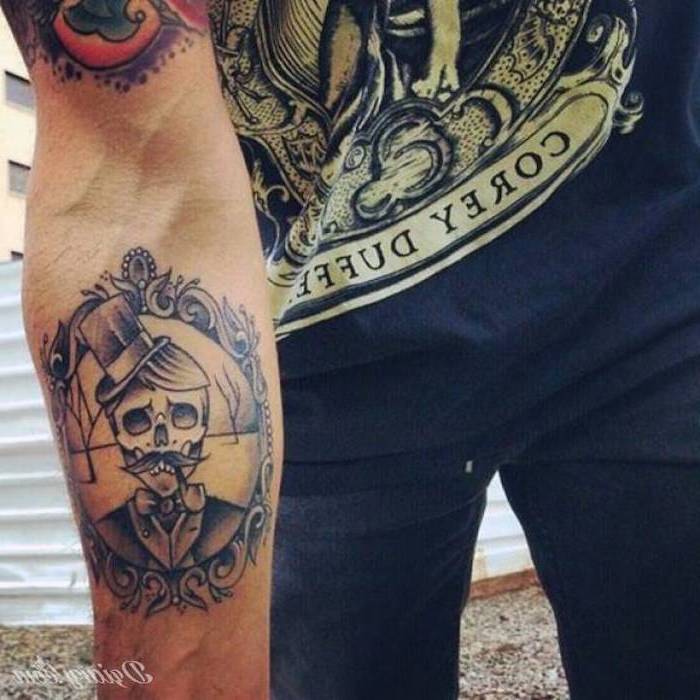 man wearing all black, tribal tattoos for men, skull with a moustache, hat and a pipe, inside a frame