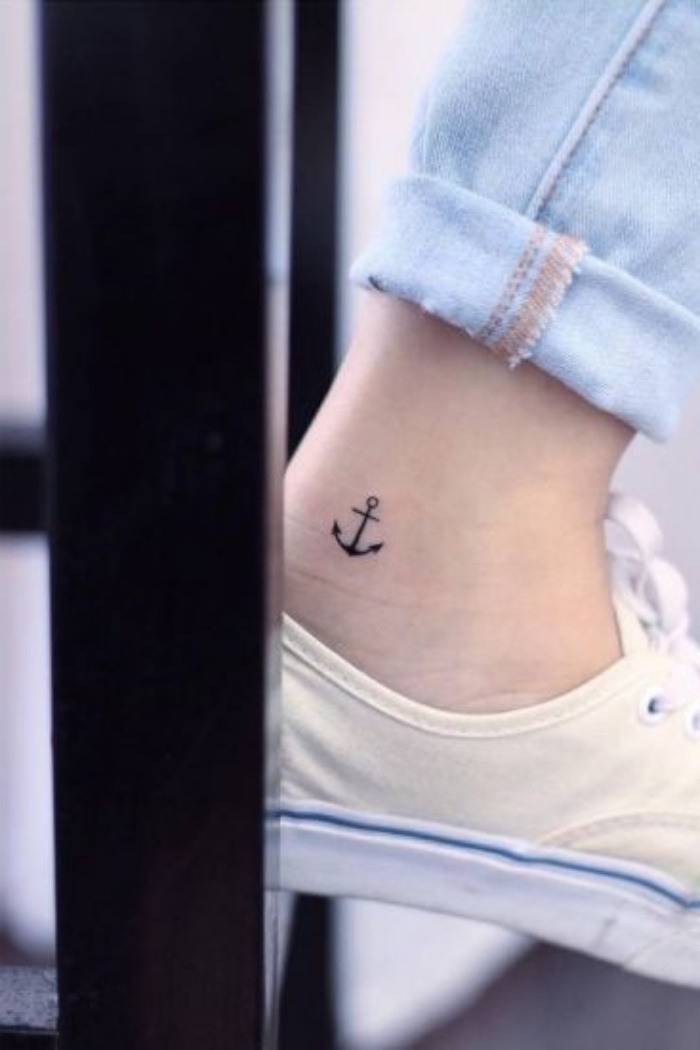 small sunflower tattoo, small anchor ankle tattoo, person wearing washed jeans, white sneakers