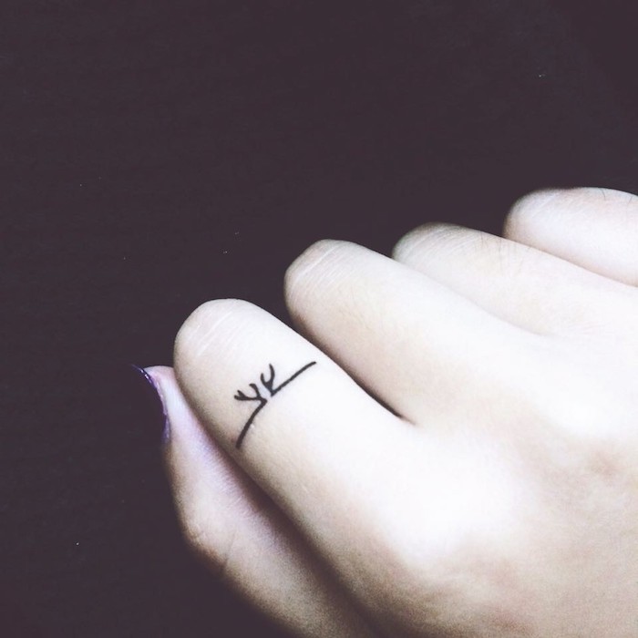 small tattoo, on the finger, hand in a fist, couple finger tattoos, black background