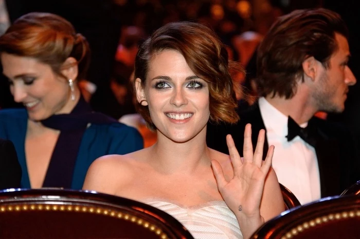cool small tattoos for guys, kristen stewart waving, wearing a white dress, with a short brown hair
