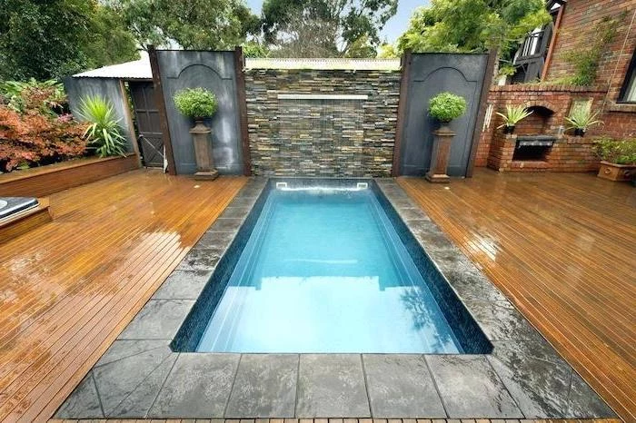 small pool with a fountain, surrounded by cement tiles, small backyard ideas, potted plants, planted bushes
