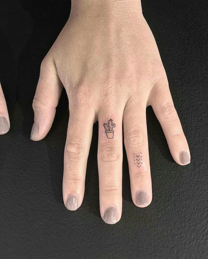 small potted cactus, middle finger tattoo, dots and arrows, ring finger tattoo, crown finger tattoo