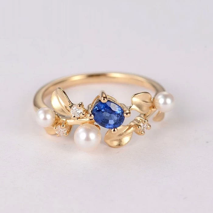 golden band with pearls, non traditional wedding rings, small sapphire stone in the middle