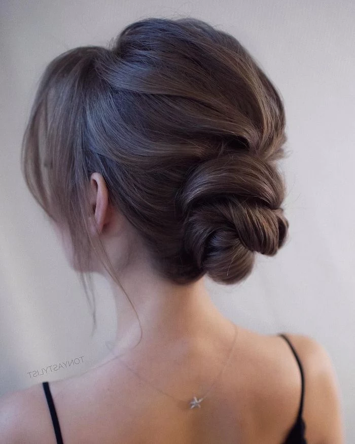 wedding hairstyles for medium hair, brown hair in a low updo, black straps, star necklace, white background