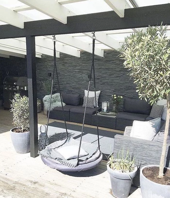 swing hanging from the ceiling, garden furniture, with colourful throw pillows, small yard landscaping ideas
