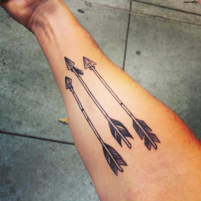 three arrows, pointing down, forearm tattoo, upper arm tattoos, tiled cement floor