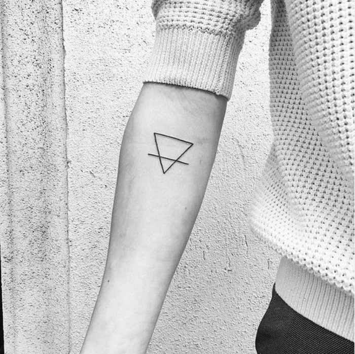 small tattoo ideas for women, small triangle forearm tattoo, person wearing a white sweater